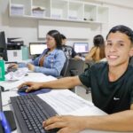 Estudantes trabalham em computadores durante atividade de estágio no Distrito Federal