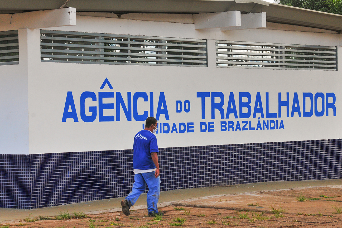 Fachada da Agência do Trabalhador de Brazlândia com uma pessoa caminhando em frente à unidade