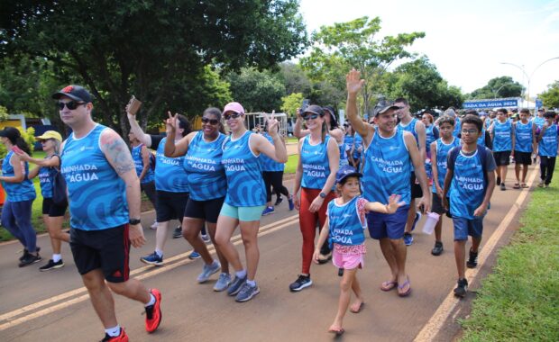 Grupo de adultos e crianças participa de uma caminhada ao ar livre