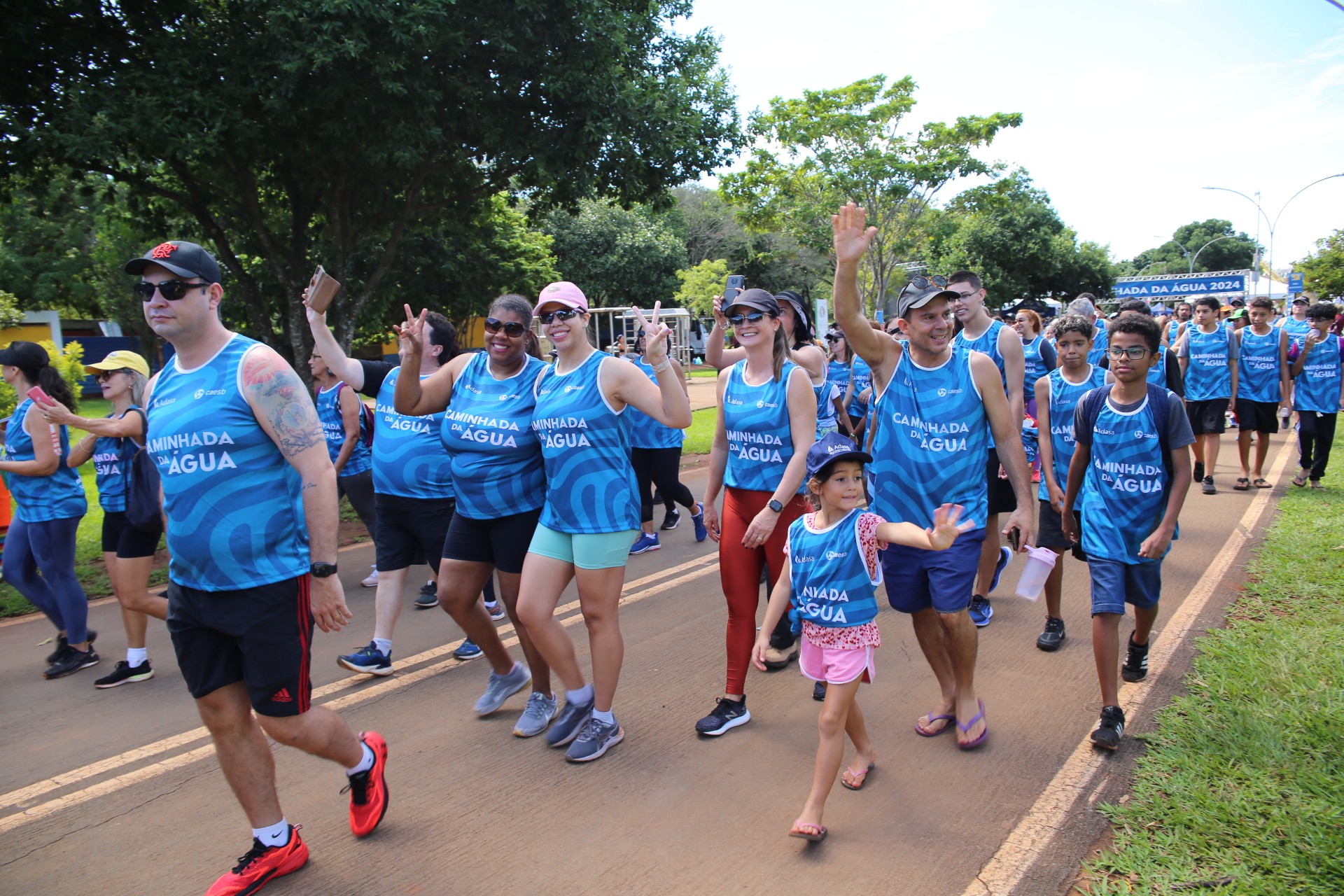 Grupo de adultos e crianças participa de uma caminhada ao ar livre