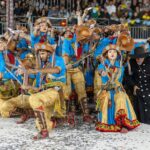 Quadrilha junina se apresenta com figurinos coloridos diante do público