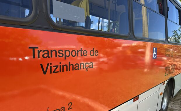 Lateral de um ônibus laranja do serviço Transporte de Vizinhança do Distrito Federal