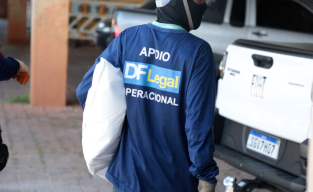 Servidor da DF Legal transporta pertences durante uma ação de acolhimento