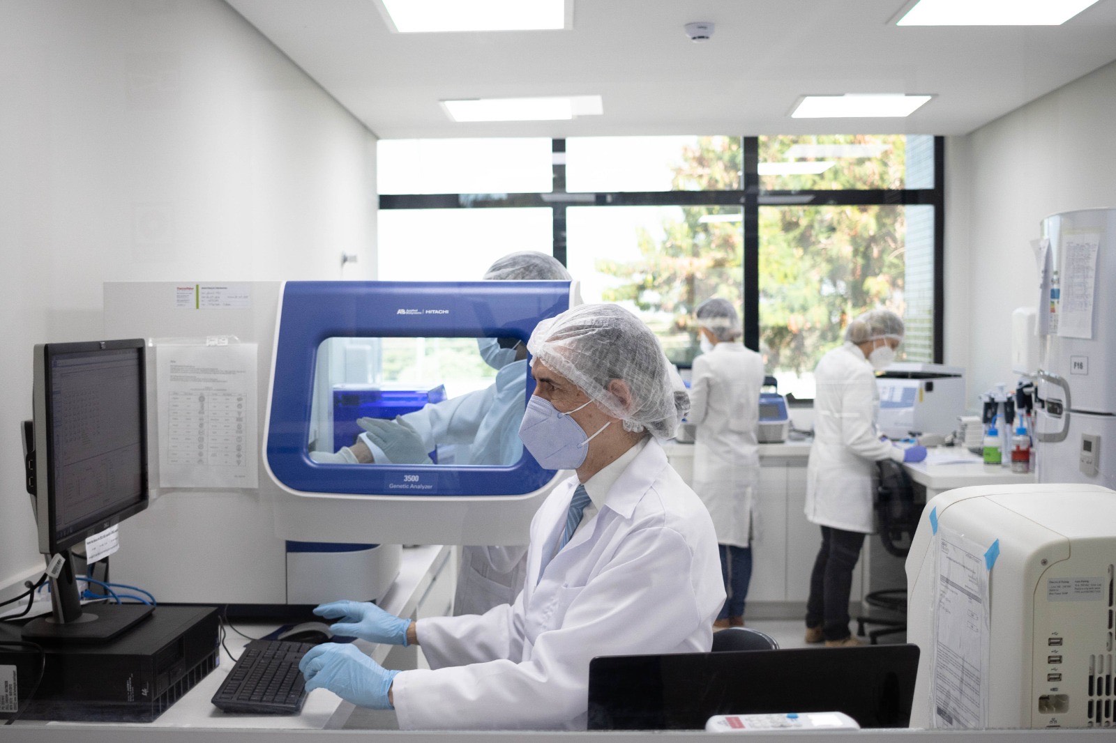 Peritos trabalham em laboratório equipado para análise de perfis genéticos