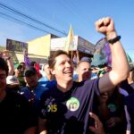Daniel Vilela ergue o braço durante ato de campanha cercado por apoiadores