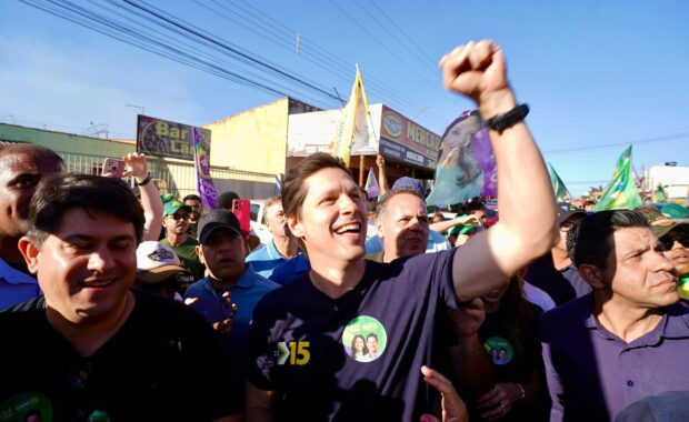 Daniel Vilela ergue o braço durante ato de campanha cercado por apoiadores