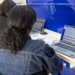 Mulher recebe orientação diante de um computador em uma unidade do CRMB