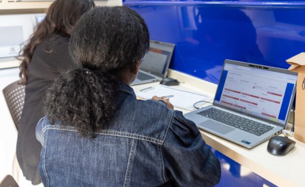 Mulher recebe orientação diante de um computador em uma unidade do CRMB