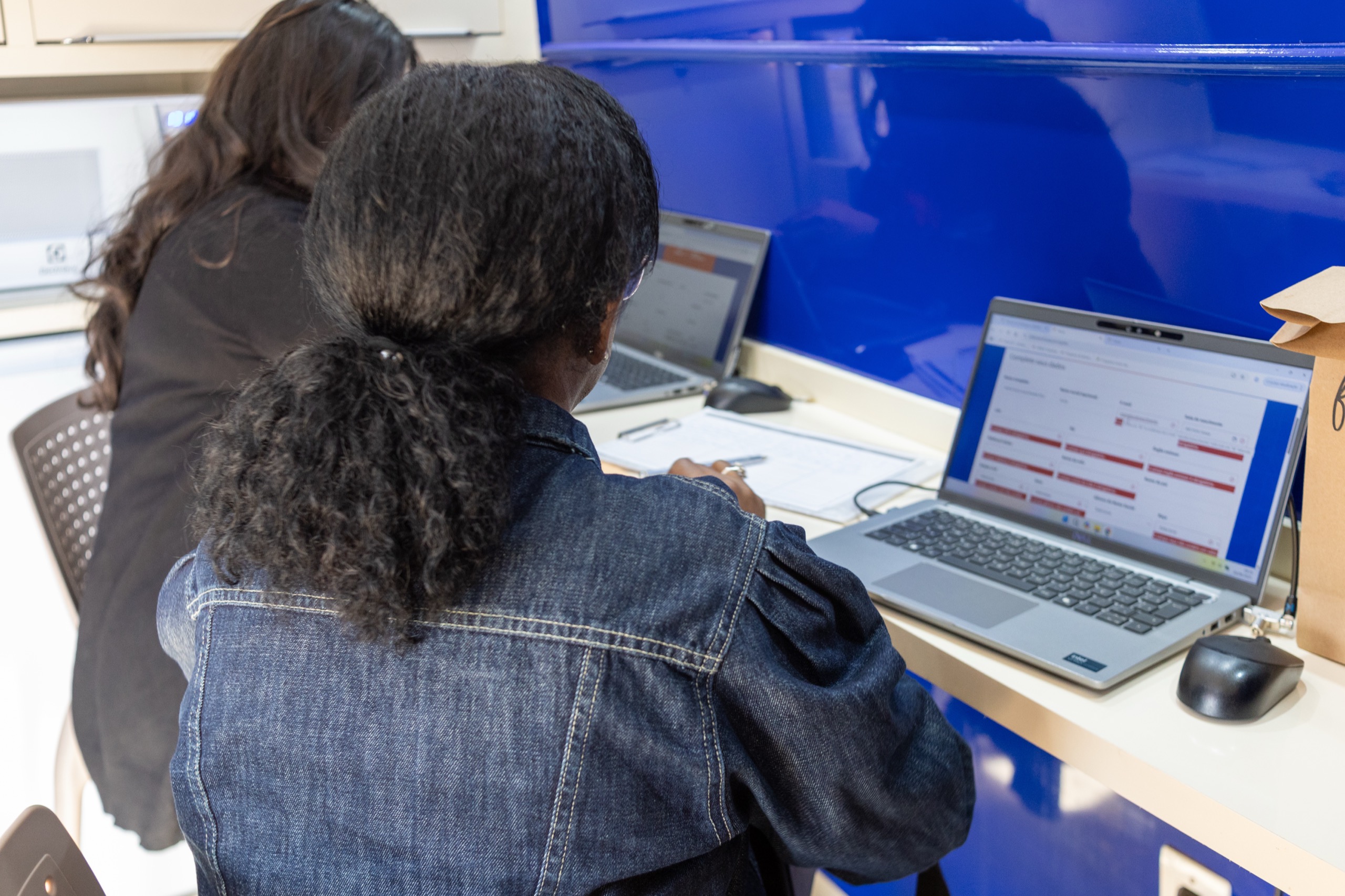 Mulher recebe orientação diante de um computador em uma unidade do CRMB