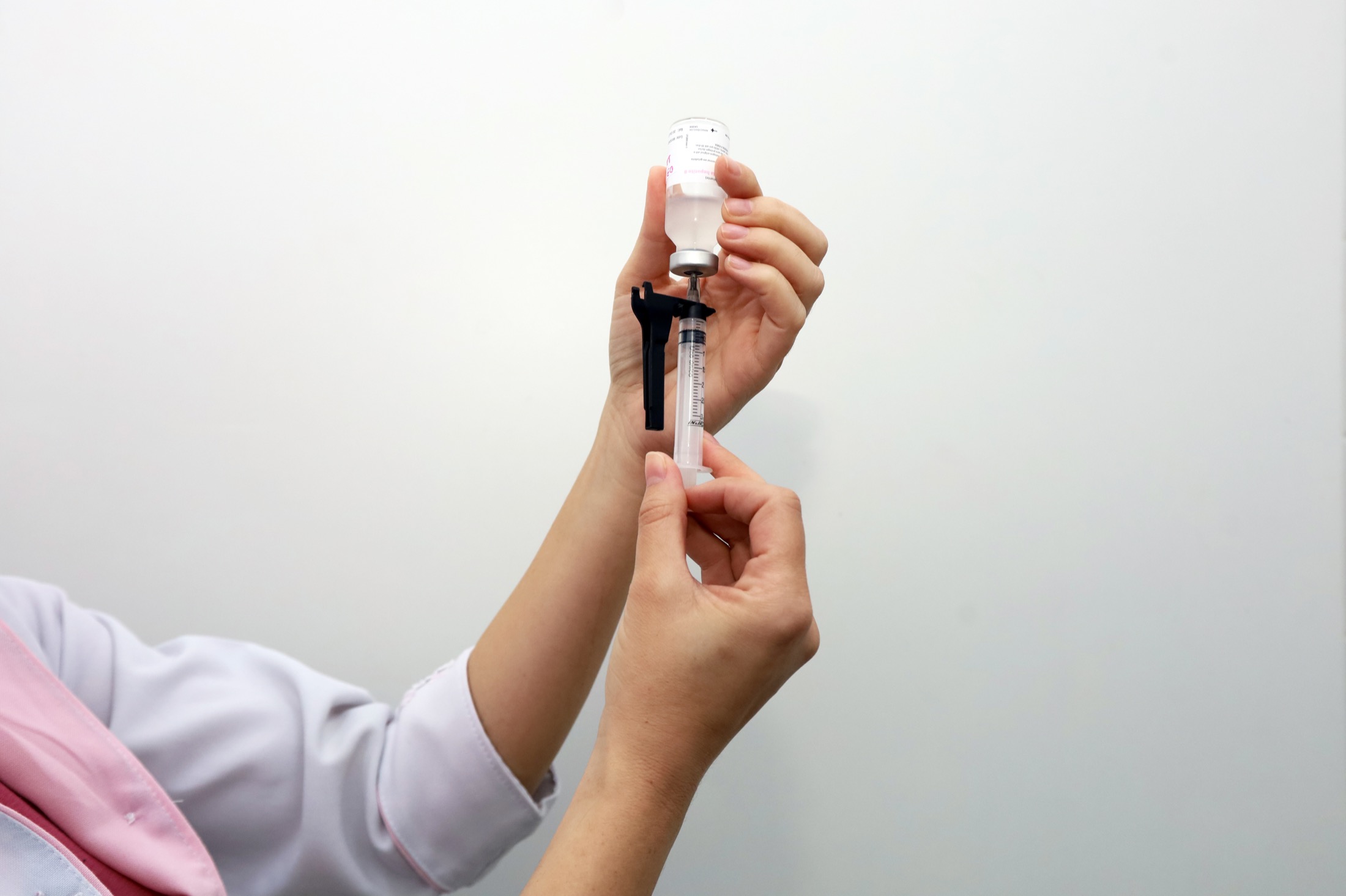 Profissional de saúde prepara uma dose de vacina em seringa