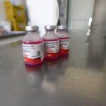 Frascos de vacina antirrábica veterinária sobre bancada