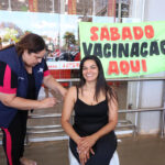 Profissional de saúde aplica uma vacina no braço de uma mulher