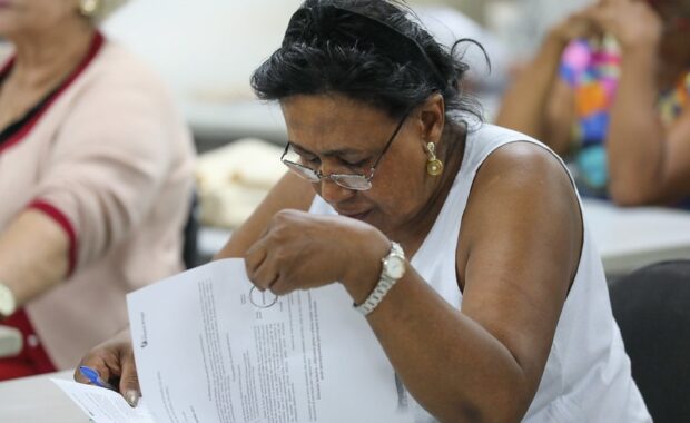 Candidata preenche prova de concurso público em sala de aplicação