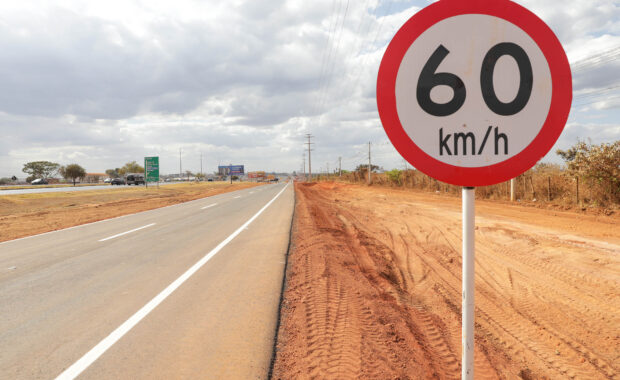 Marginal da BR-040 sinalizada ao lado de placa de velocidade máxima de 60 quilômetros por hora