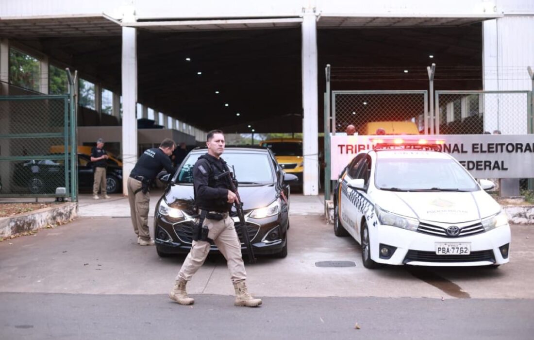 Policiais acompanham a saída de veículos do depósito do TRE-DF
