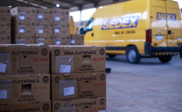 Caixas com urnas eletrônicas ao lado de veículos usados no transporte
