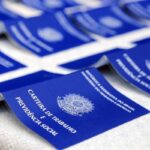 Carteiras de Trabalho estão dispostas sobre uma mesa