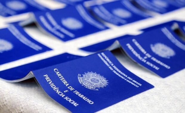 Carteiras de Trabalho estão dispostas sobre uma mesa