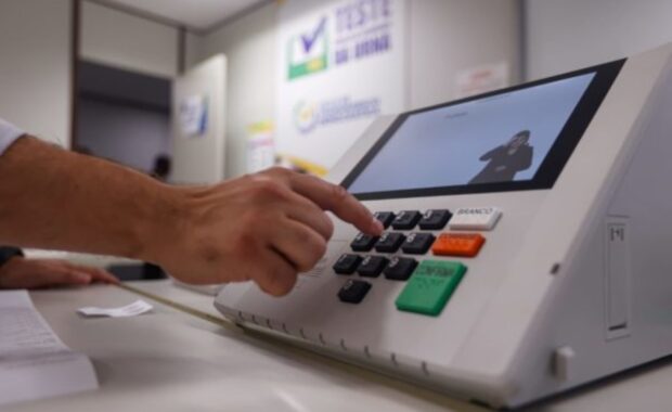 Eleitor pressiona uma tecla da urna eletrônica durante a votação