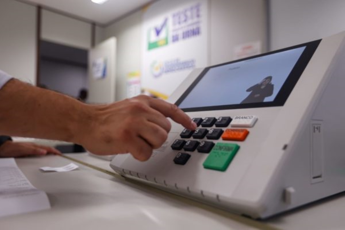 Eleitor pressiona uma tecla da urna eletrônica durante a votação